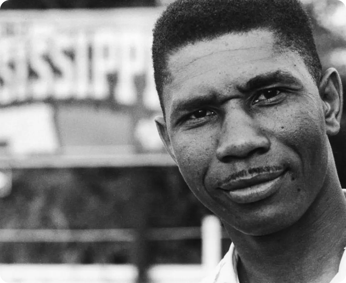 A man looking at the camera in black and white.